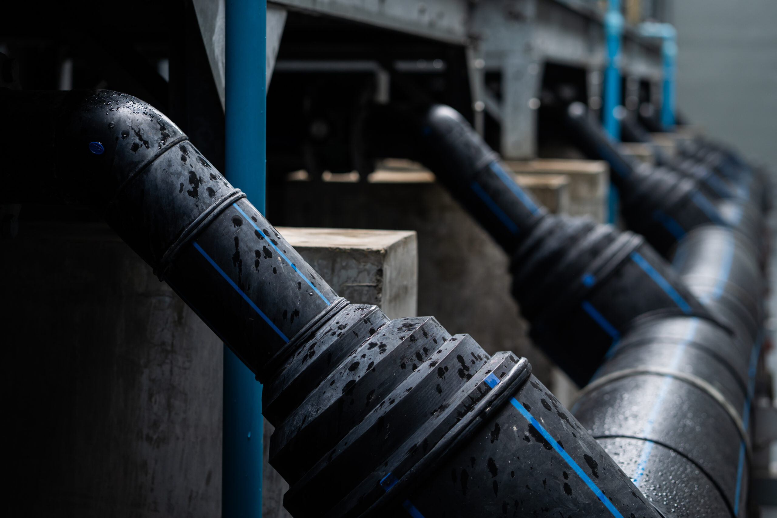 A series of black pipes with blue stripes are shown